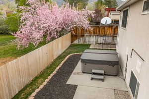Fenced backyard with a patio and a hot tub