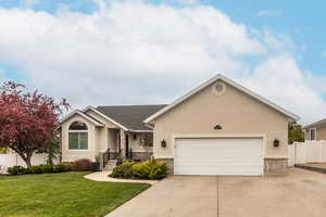 Single story home featuring stucco siding, a garage, concrete driveway, and covered porch