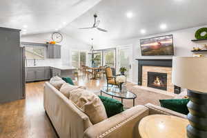 Living area with a fireplace, light wood-style floors, recessed lighting, and ceiling fan