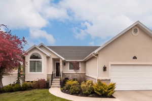 Ranch-style home featuring stucco siding, a garage, concrete driveway, and a front yard