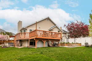 Back of property with a fenced backyard, a garden, a deck, and a chimney