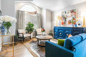 Sitting room with light wood-style floors and lofted ceiling