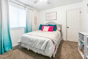 Bedroom featuring dark carpet and ceiling fan