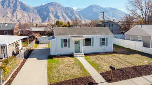 View of front of home with a mountain view, roof with shingles, and driveway