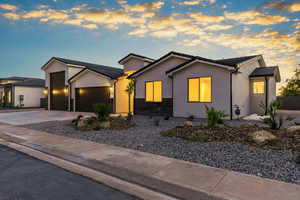 View of front of home with stone siding, a garage, concrete driveway, a tile roof, and stucco siding