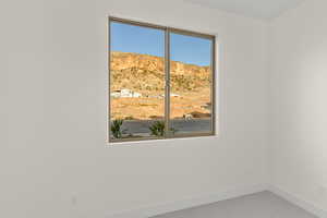 Spare room with baseboards and carpet flooring