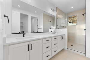 Full bathroom featuring double vanity, a walk in shower, and recessed lighting