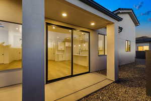 View of exterior entry with stucco siding and a sink