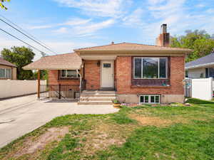 View of front of house with brick siding and a chimney
