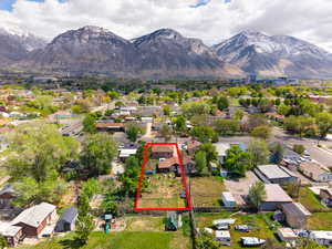 Aerial view of residential area with property parcel outlined and a mountain backdrop