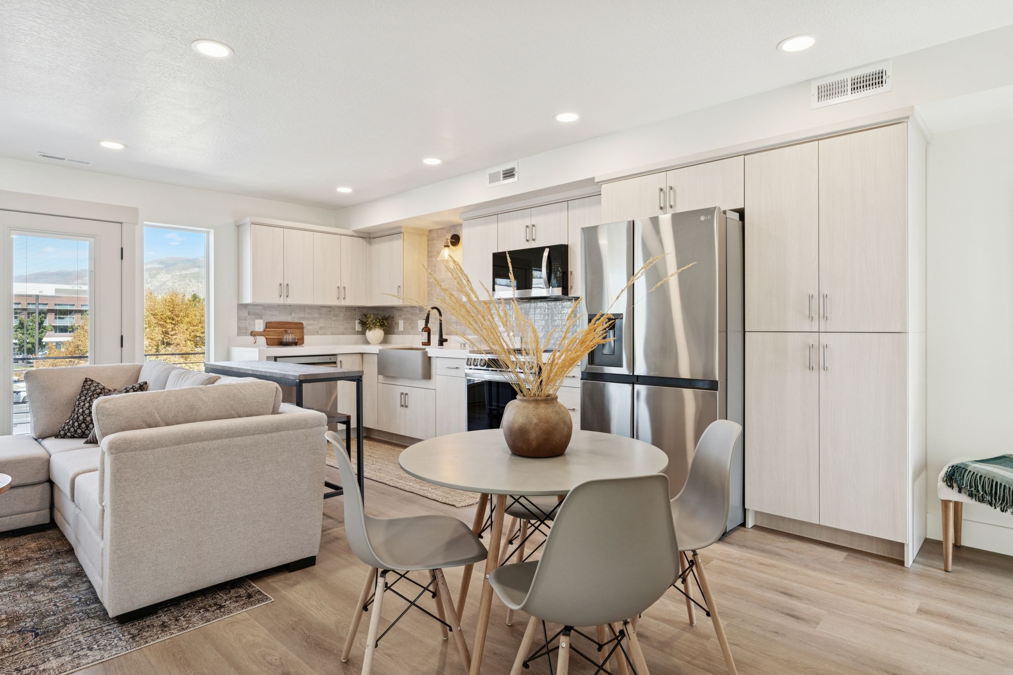 Kitchen with stainless steel appliances, light countertops, light wood finished floors, recessed lighting, and tasteful backsplash