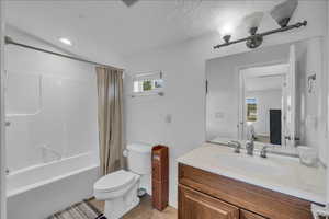 Bathroom with vanity, plenty of natural light, shower / bathtub combination with curtain, and light tile patterned flooring