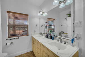 Bathroom featuring toilet and double vanity