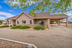 Ranch-style home with stucco siding, roof with shingles, and stone siding