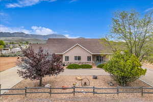 Ranch-style house with stone siding, stucco siding, a shingled roof, and a mountain view