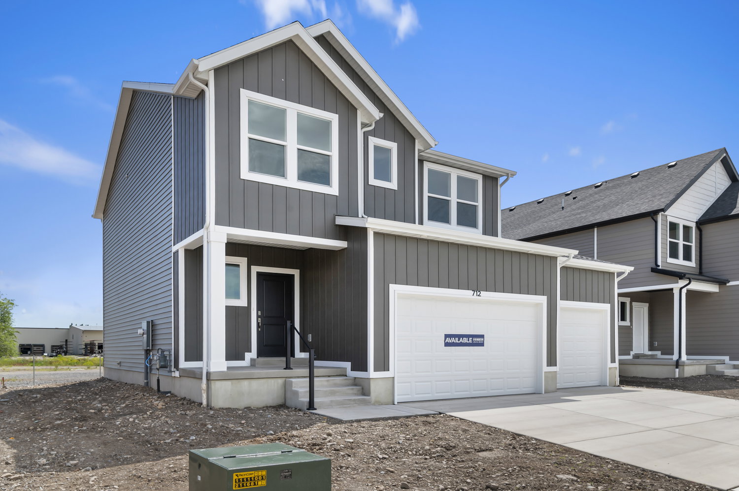 Contemporary two-story residence featuring a gray and white exterior with vertical and horizontal siding