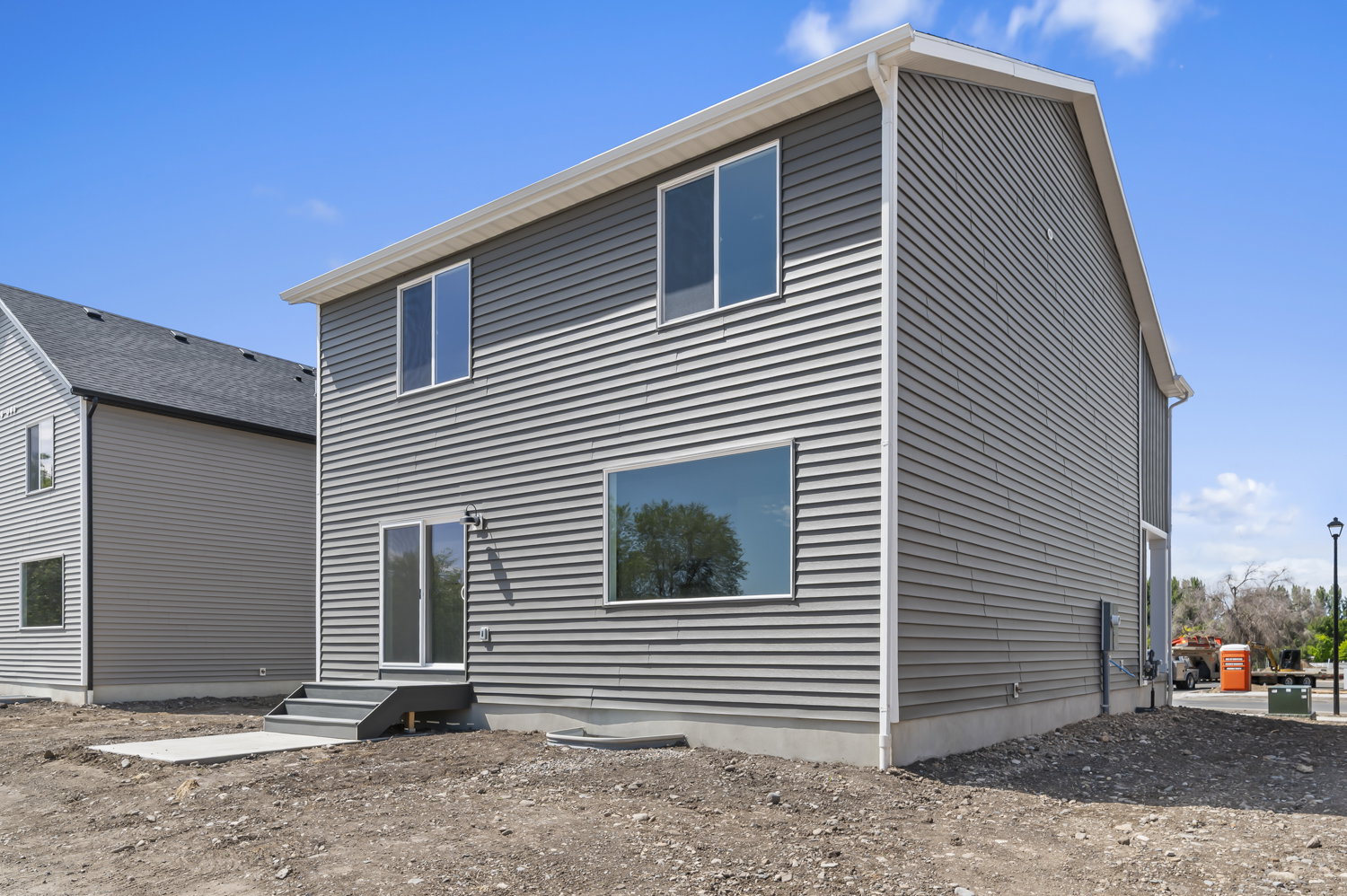 Modern two-story residence featuring gray horizontal siding and white trim