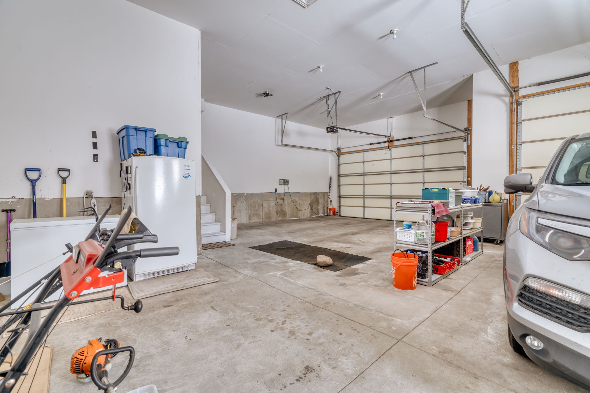 Garage with freestanding refrigerator and refrigerator