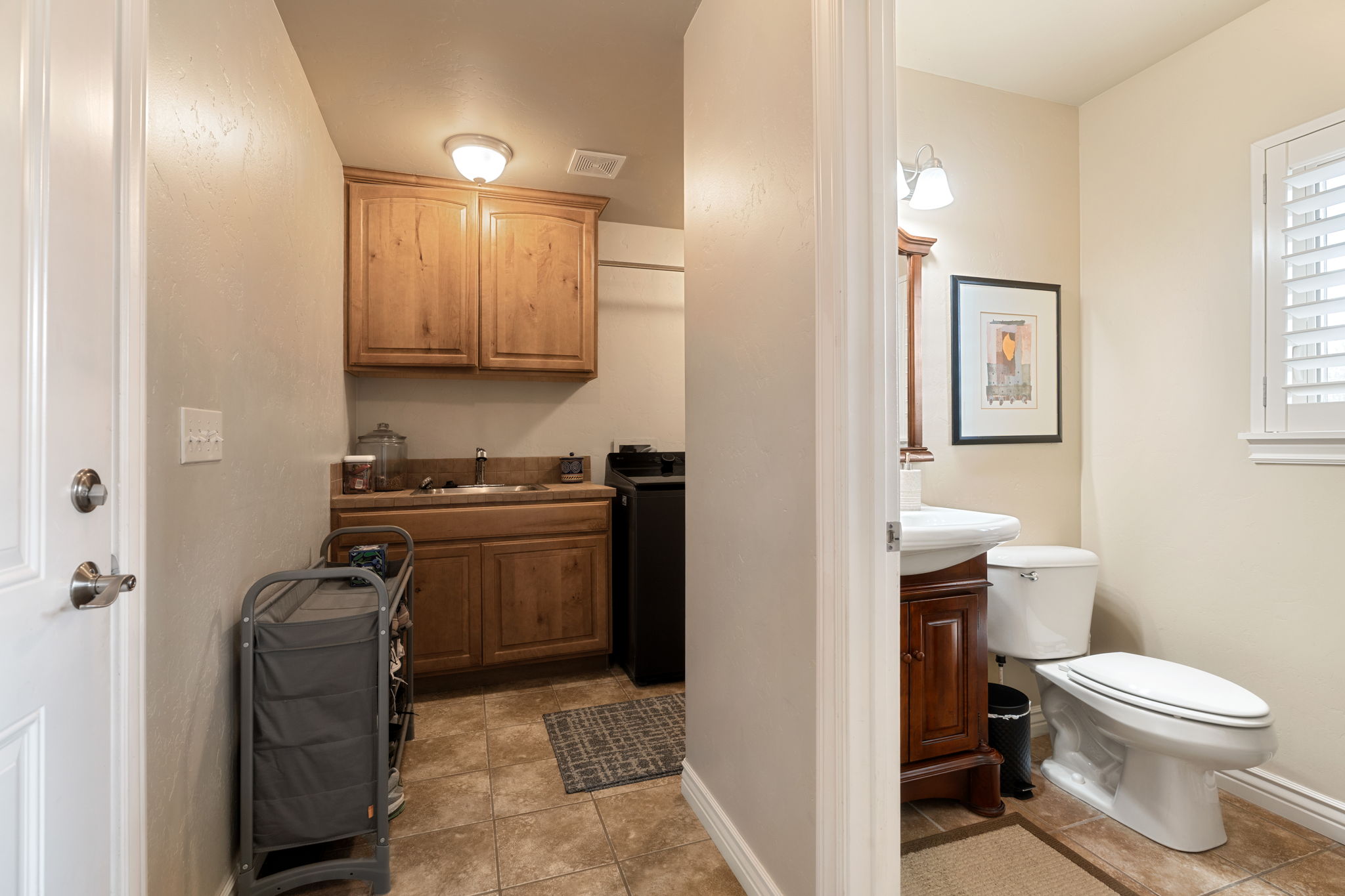 Bathroom with washer / dryer, vanity, and light tile patterned floors