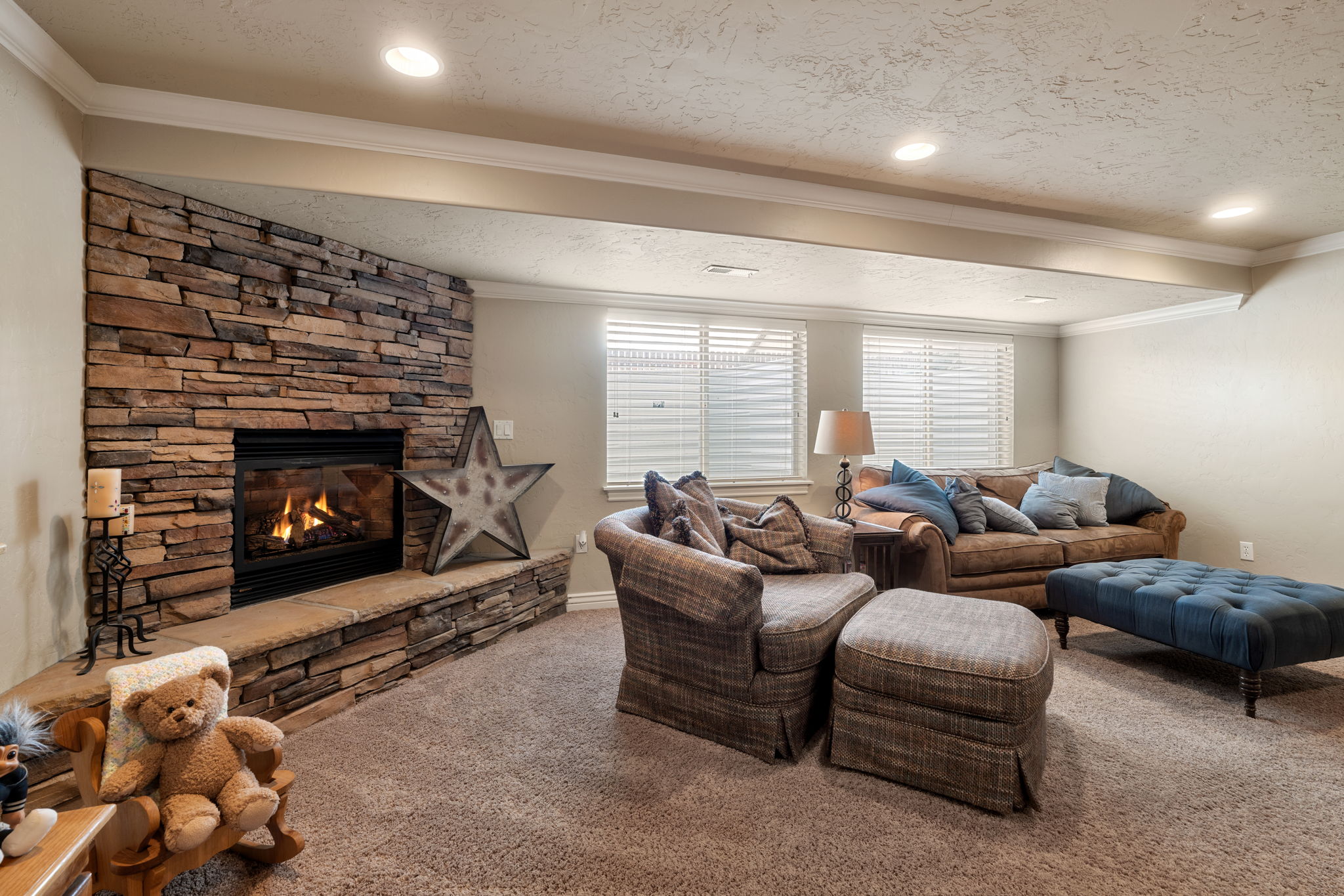 Living room with ornamental molding, carpet, a fireplace, and a textured ceiling