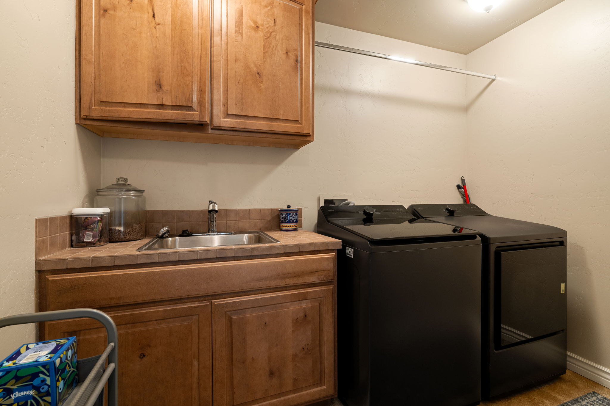 Laundry area featuring a textured wall, cabinet space, and washer and clothes dryer