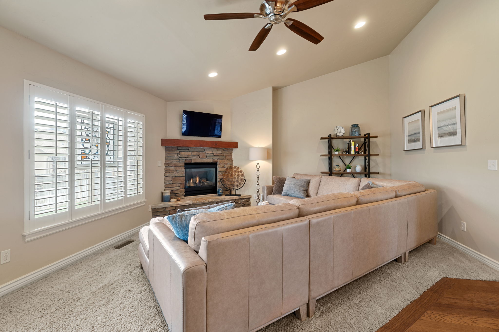 Living room with a ceiling fan, a fireplace, recessed lighting, carpet, and vaulted ceiling