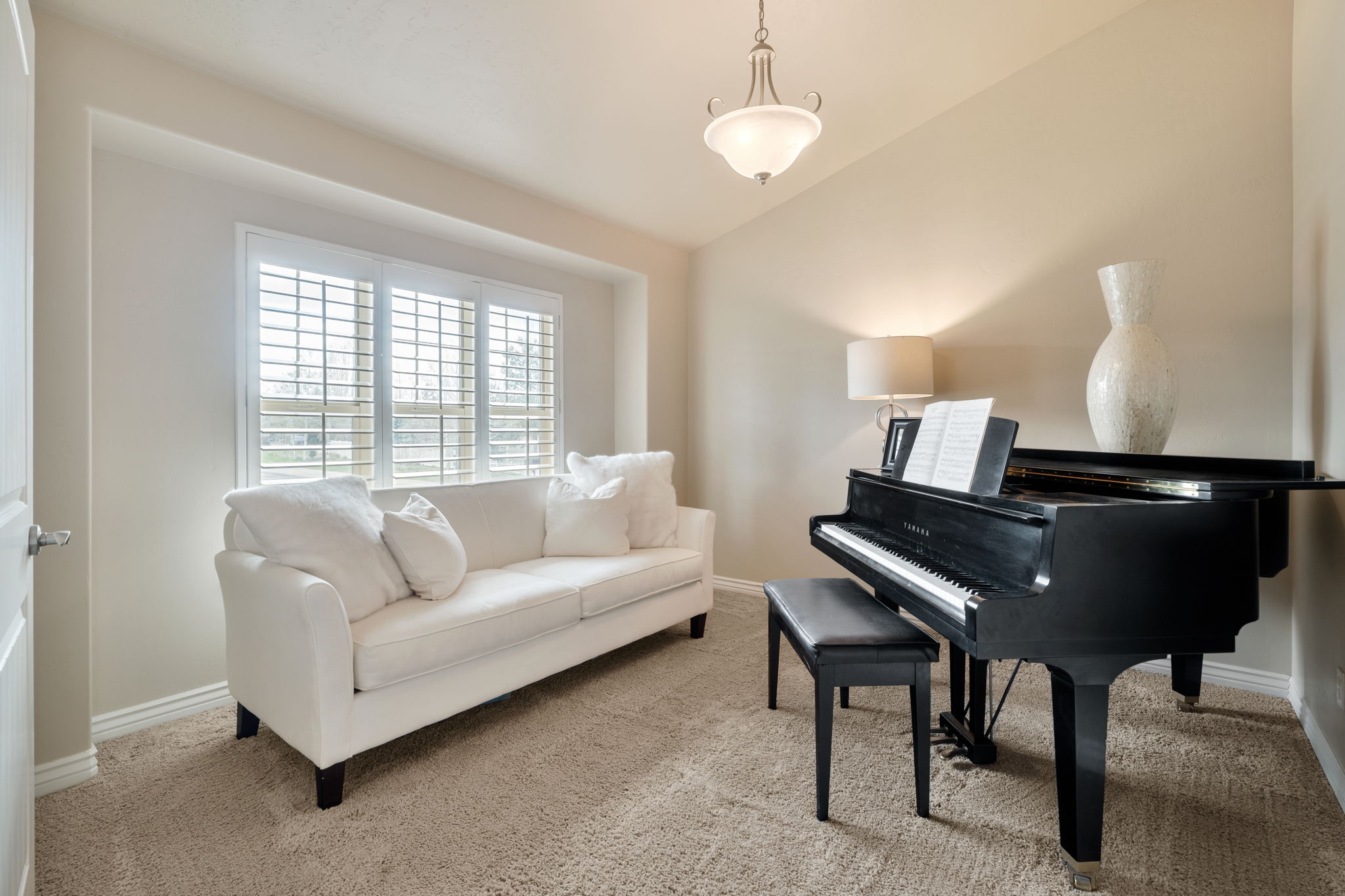 Sitting room with lofted ceiling and light colored carpet