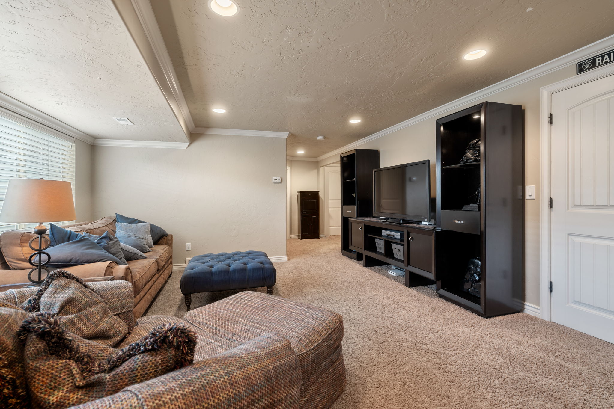 Living area with crown molding, light carpet, a textured ceiling, and recessed lighting