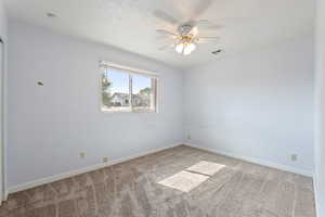 Empty room with light carpet and ceiling fan