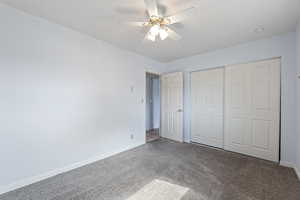 Unfurnished bedroom featuring carpet flooring, a closet, and a ceiling fan