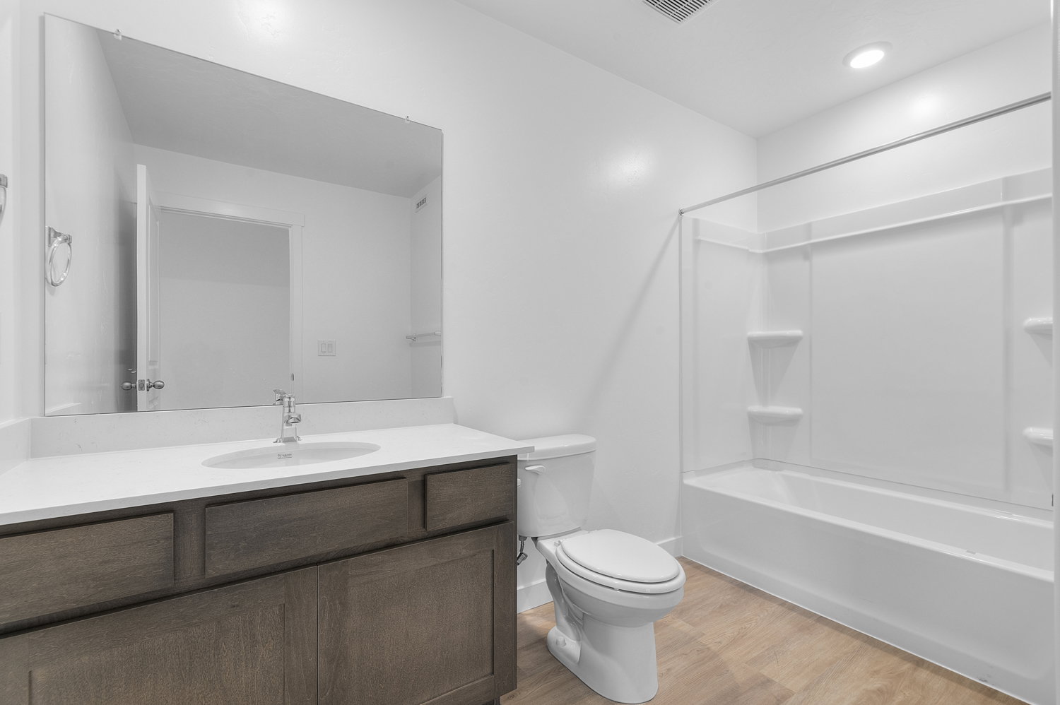 Bathroom with vanity, light wood-style flooring, and tub / shower combination
