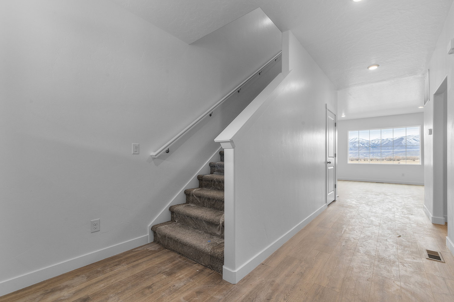 Stairway featuring hardwood / wood-style floors and recessed lighting