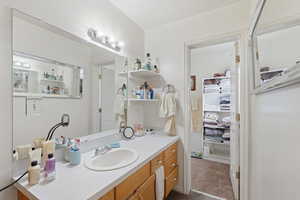 Bathroom with vanity and a closet