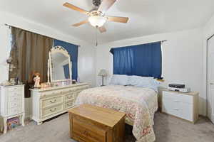 Bedroom with light colored carpet and a ceiling fan