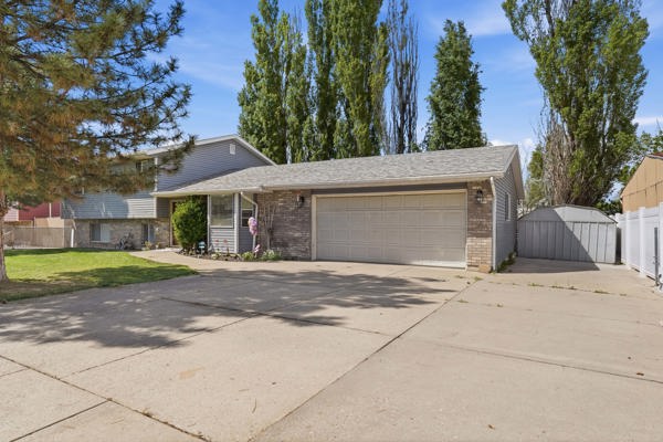 Split level home with concrete driveway, brick siding, and a garage