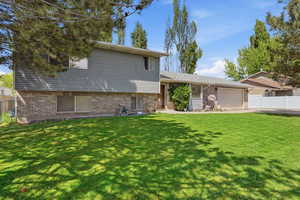 Tri-level home with brick siding and a garage