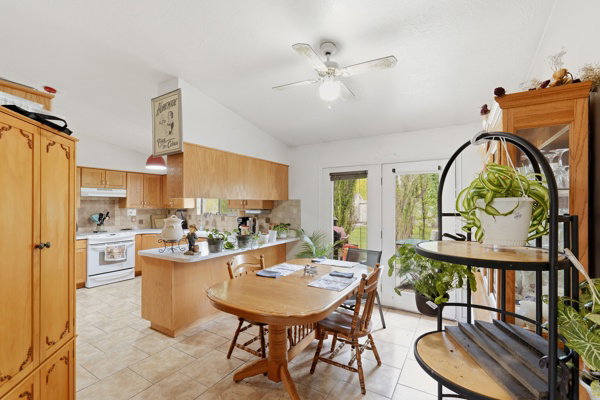 Dining room featuring a ceiling fan and vaulted ceiling