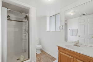 Full bathroom featuring vanity, a shower stall, and light tile patterned flooring