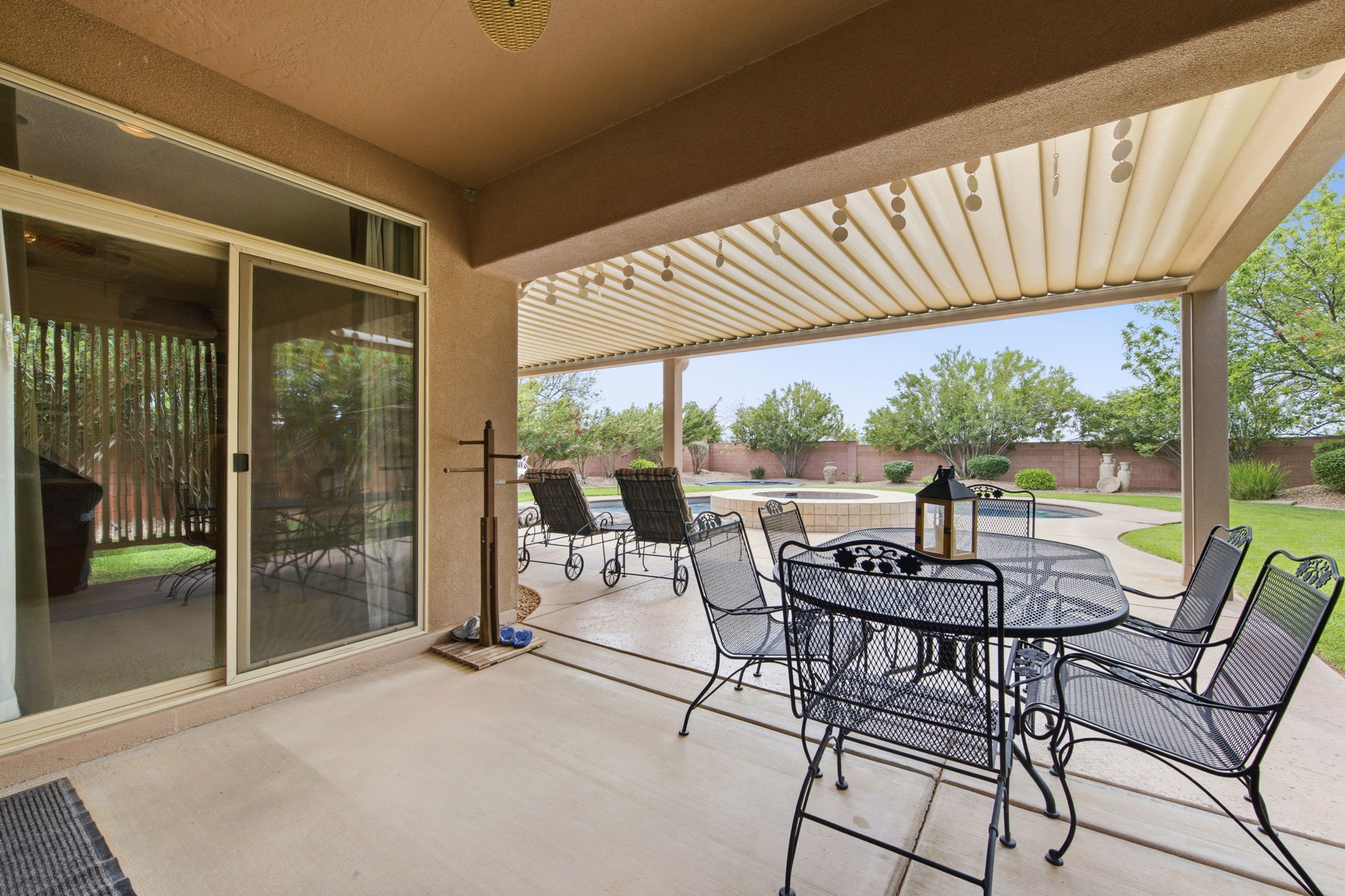 Fenced backyard with a patio, outdoor dining space, a pool with connected hot tub, and a pergola