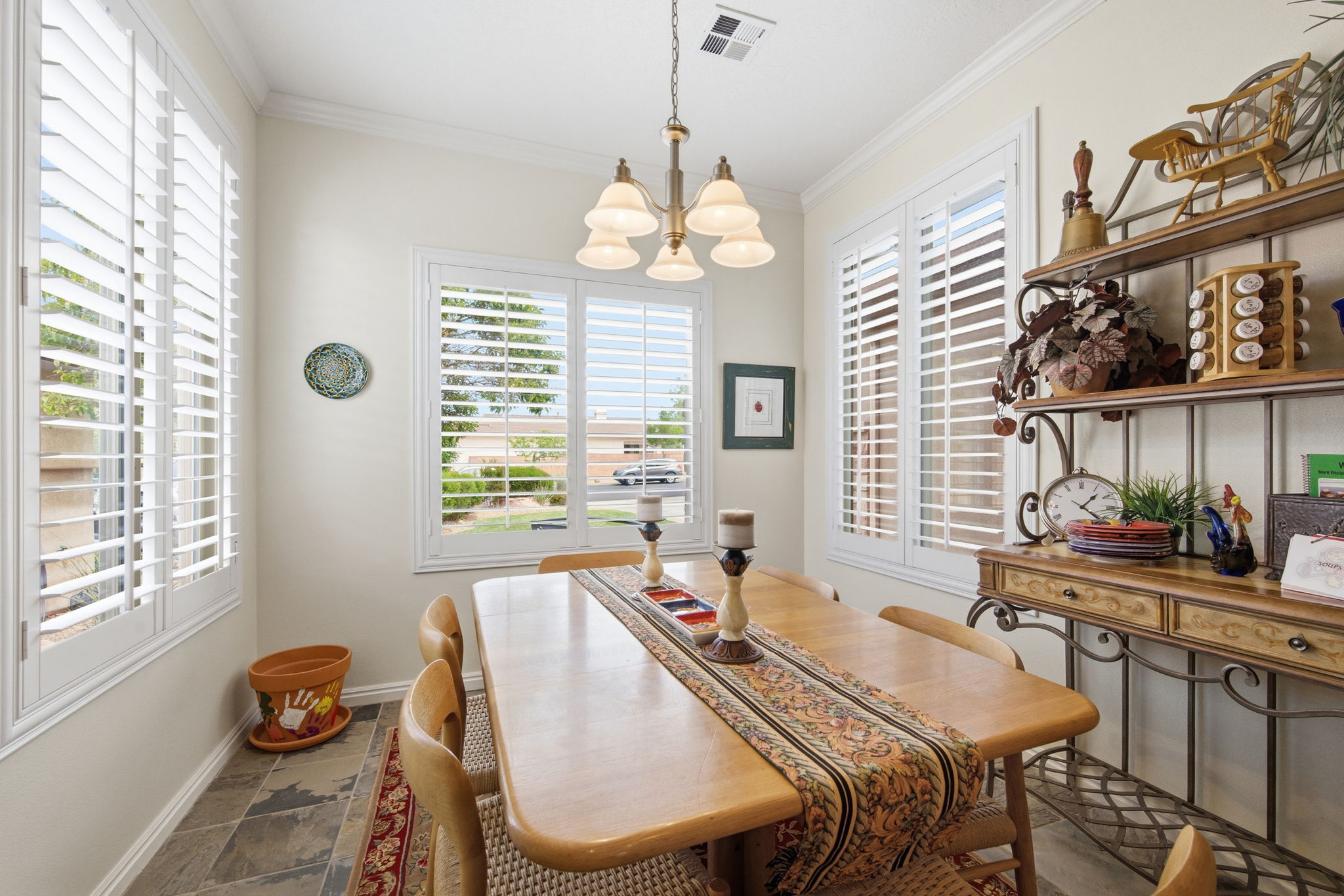 Dining room with hanging lights, crown molding, and stone finish flooring