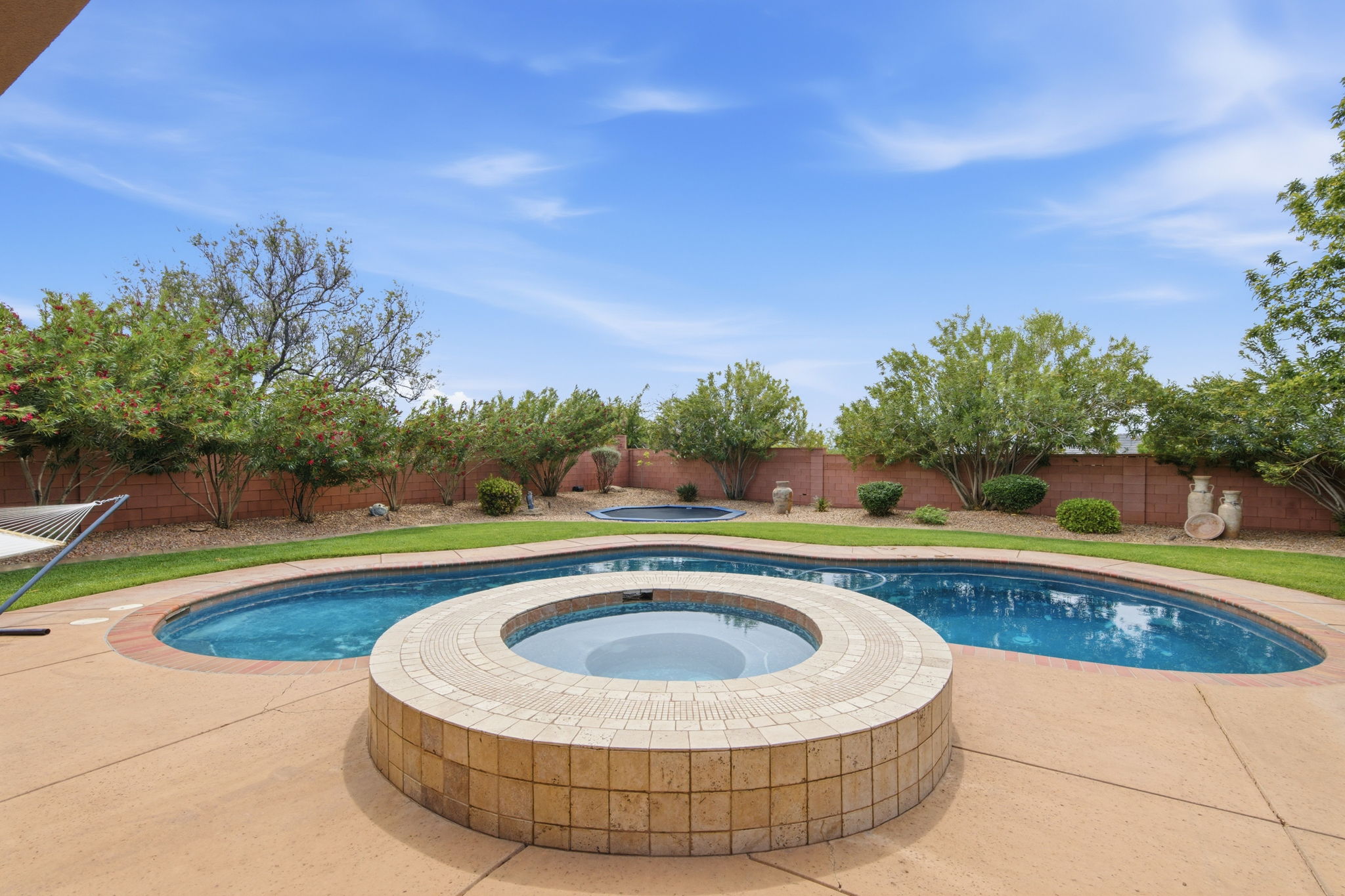 Integrated pool / hot tub featuring a fenced backyard and a patio area