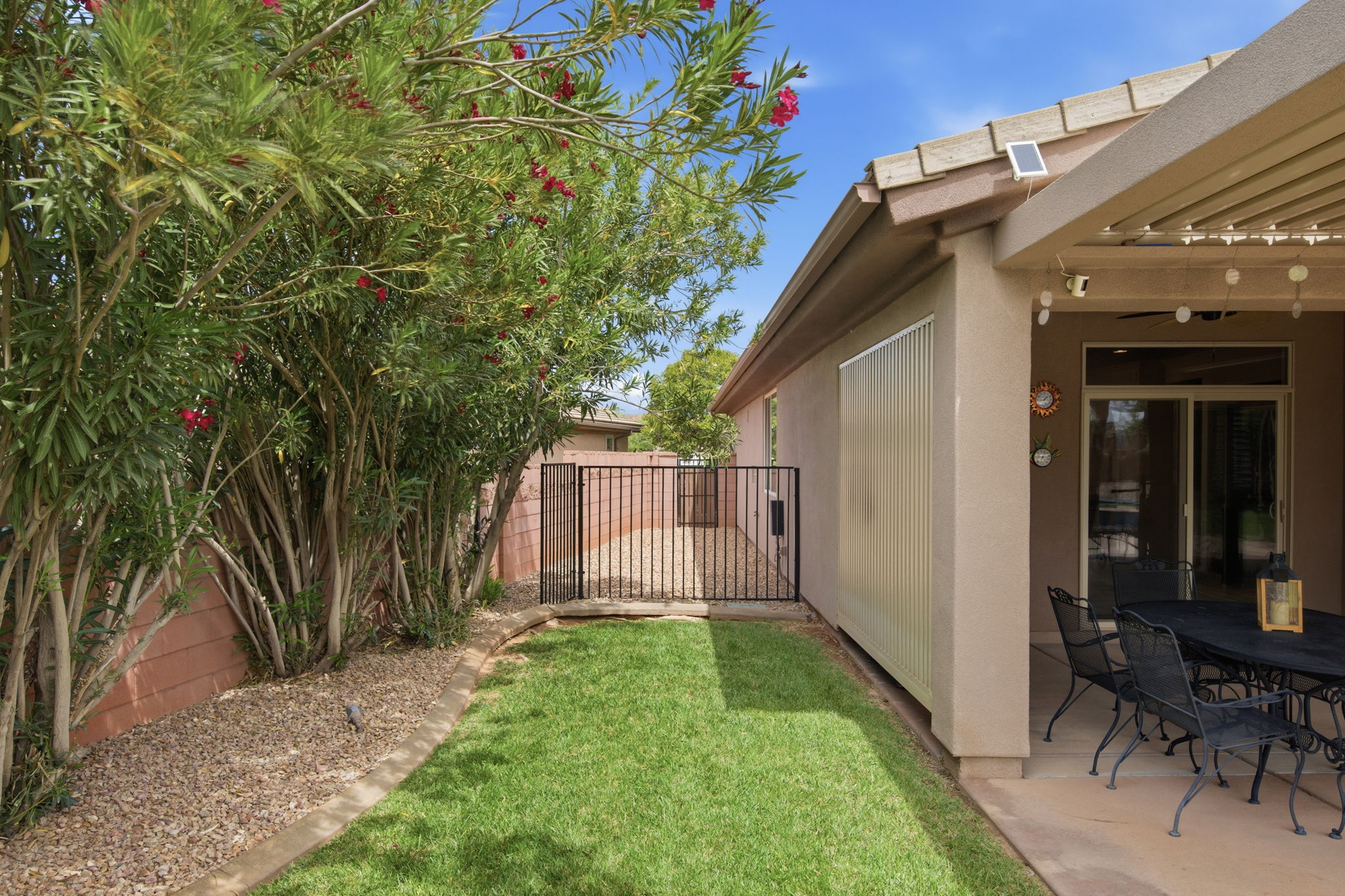 Fenced backyard with outdoor dining space and a gate