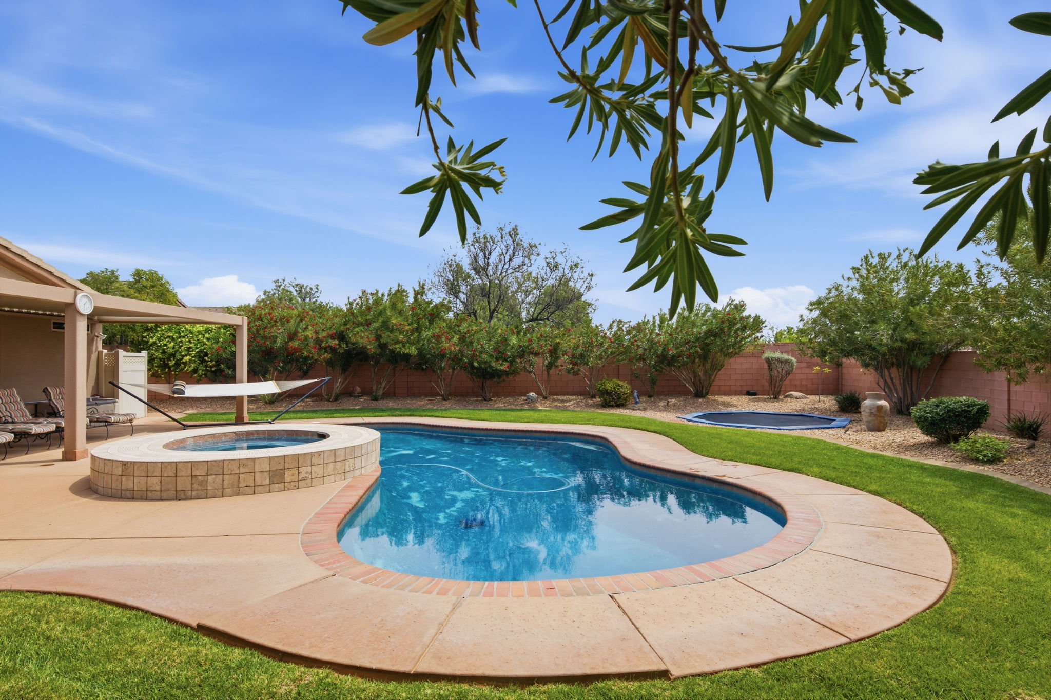 Integrated pool / spa with a patio and a fenced backyard