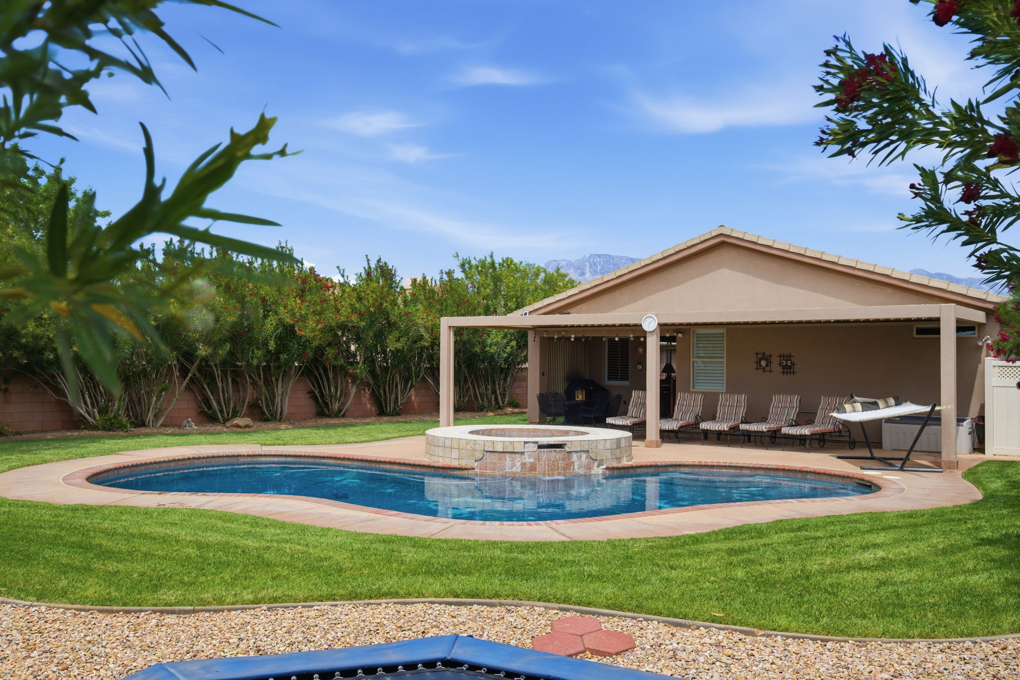 Relaxing pool / spa with a fenced backyard and a patio area
