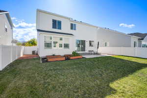 Rear view of house with a patio, a fenced backyard, a garden, and stucco siding