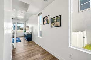 Hall featuring plenty of natural light, dark wood finished floors, and a textured ceiling