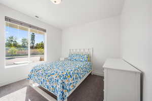 Bedroom featuring dark carpet and baseboards