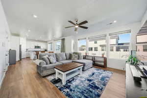 Living area featuring light wood-type flooring, recessed lighting, ceiling fan, and a textured ceiling