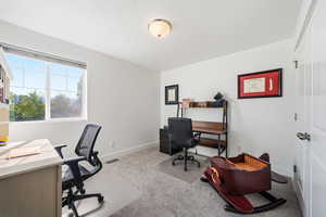 Office area with light carpet and a textured ceiling