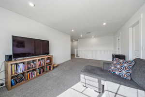 Sitting room featuring carpet flooring, recessed lighting, and a textured ceiling
